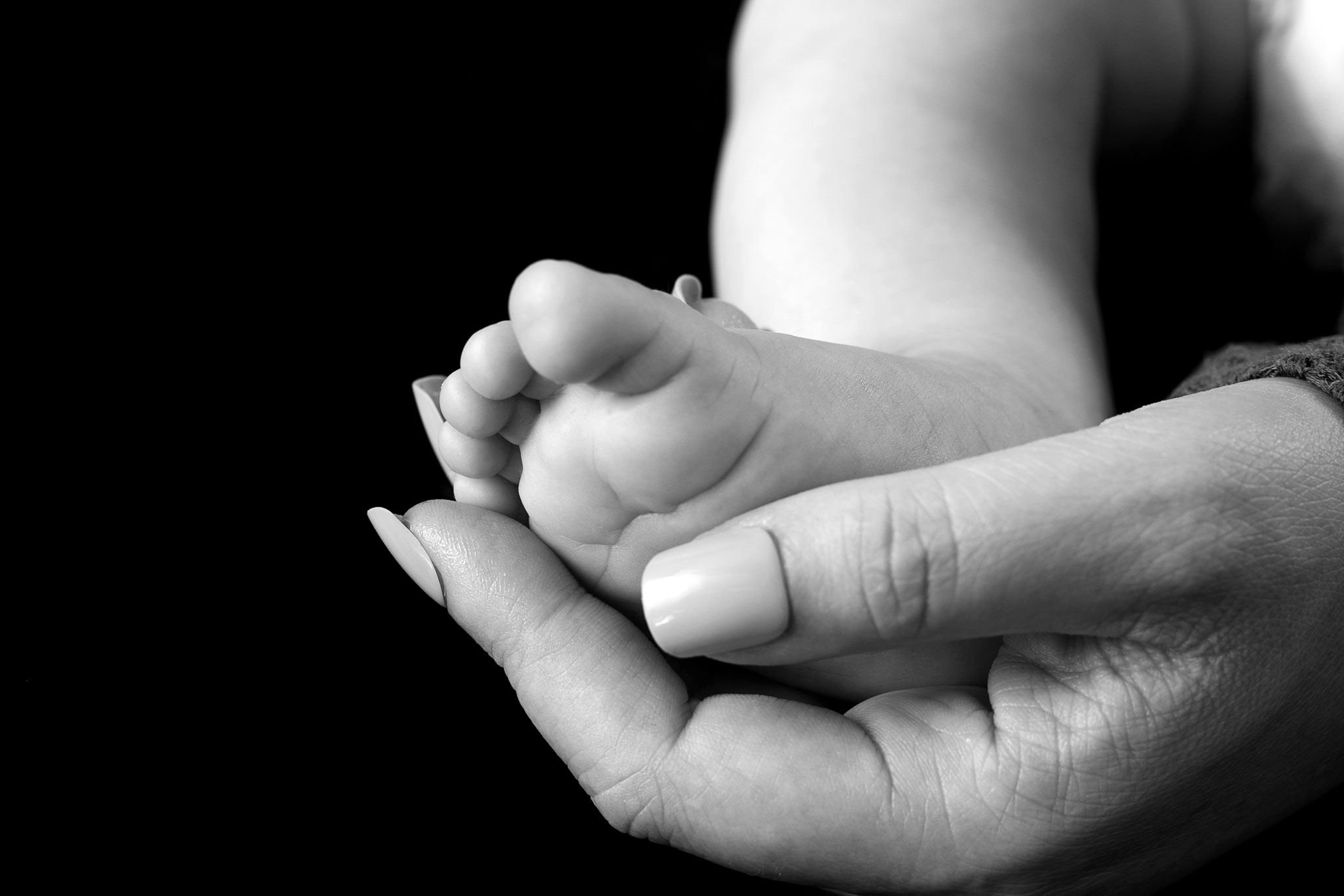 Mother cups baby's foot at Williams Photography Studio in Quincy, CA